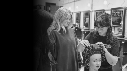 Cosmetology educator putting in a roller set in hair during training at Debutantes School of Beauty.