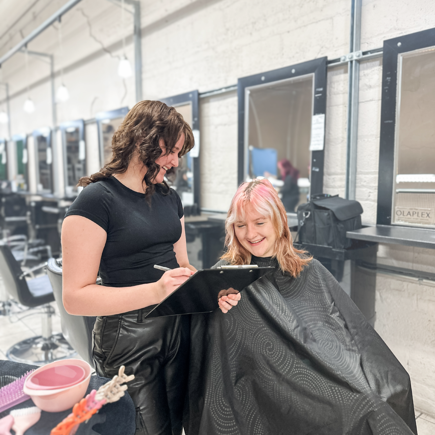 Cosmetology student consulting with a client on the salon clinic floor at Debutantes School of Beauty in DeKalb Illinois.